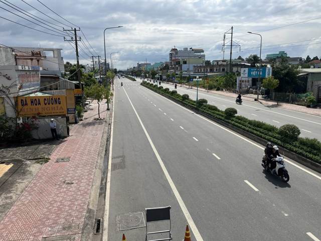 A multi-lane main road with LED street lights and a green median