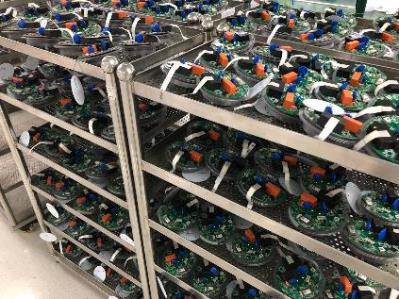 Racks holding batches of assembled iLCS electronic devices