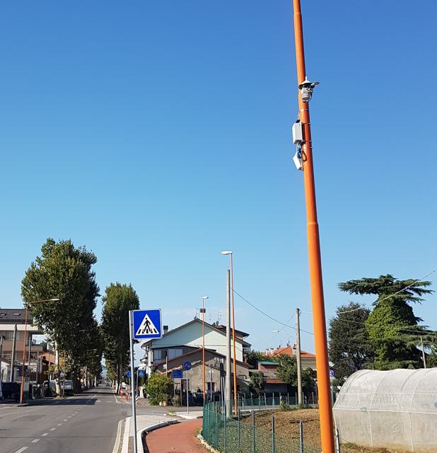 A two-lane road with LED luminaires and a pole-mounted weather station